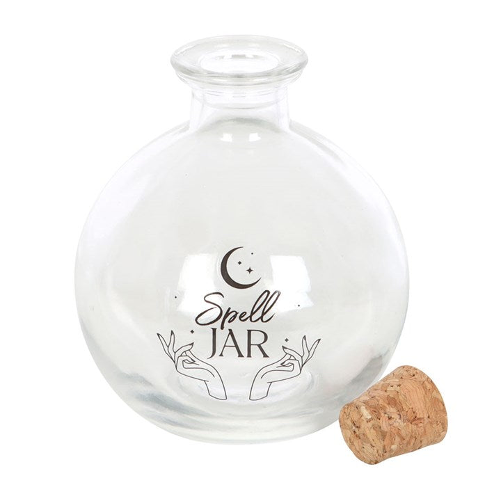 An empty, clear glass spell jar accompanied by a cork topper.