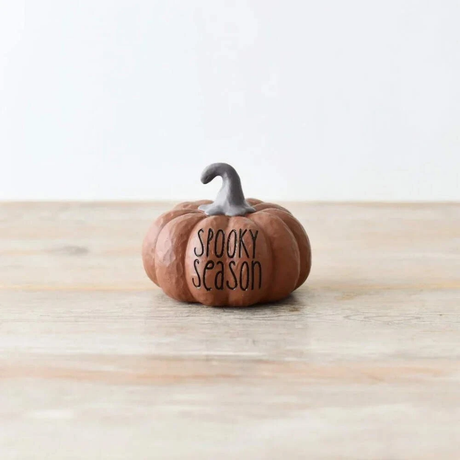 Small pumpkin-shaped decoration with 'Spooky Season' text on a wooden surface