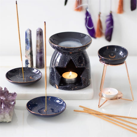 A collection of celestial themed incense holders and oil burners alongside incense sticks and crystals 