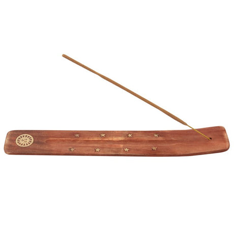 A wooden incense stick holder with golden stars and a sun design. 