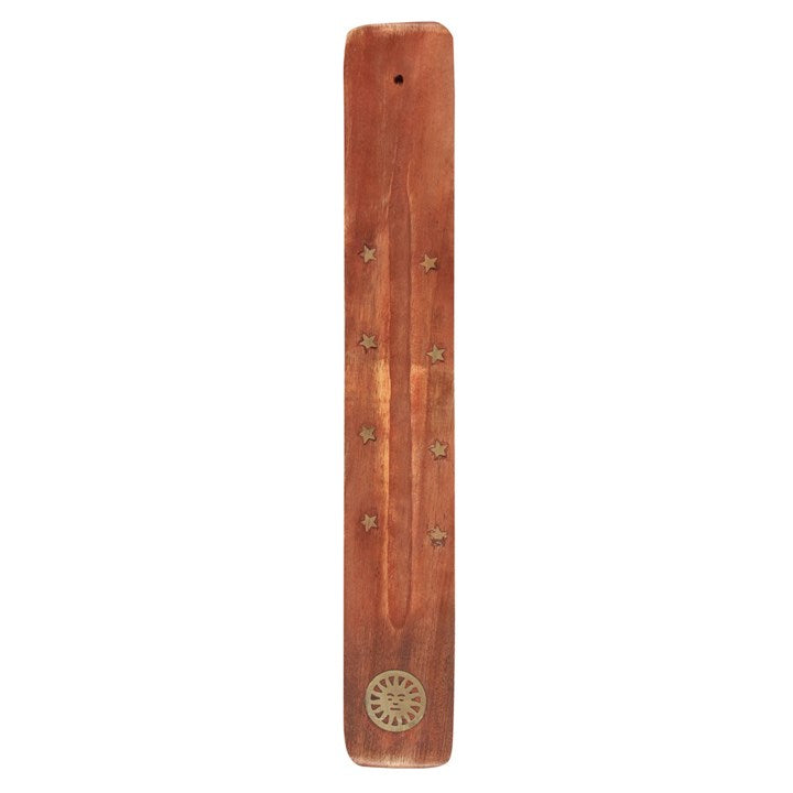 A wooden incense stick holder with golden stars and a sun design. 