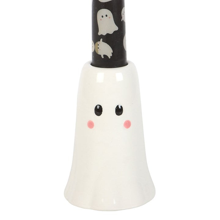 White ghost-shaped candle holder with black candle featuring ghost designs on a white background