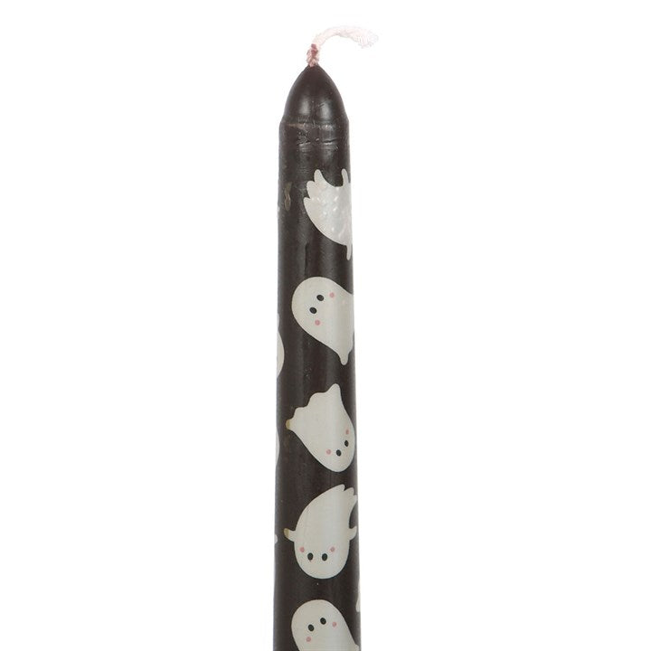 Black candle with white ghost patterns on a white background