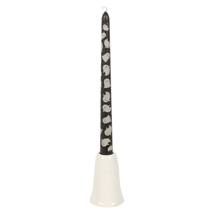 Black candle with ghost design on a white base against a white background