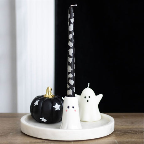 Decorative items including a black pumpkin, white ghost, and black candle with white ghosts on a white base.