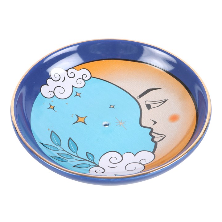 A blue ceramic incense holder with a design resembling the moon and surrounded by clouds.