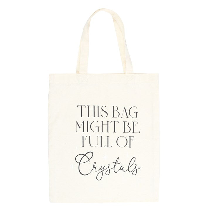 A white cotton tote bag with the text 'This bag might be full of crystals' printed on the front