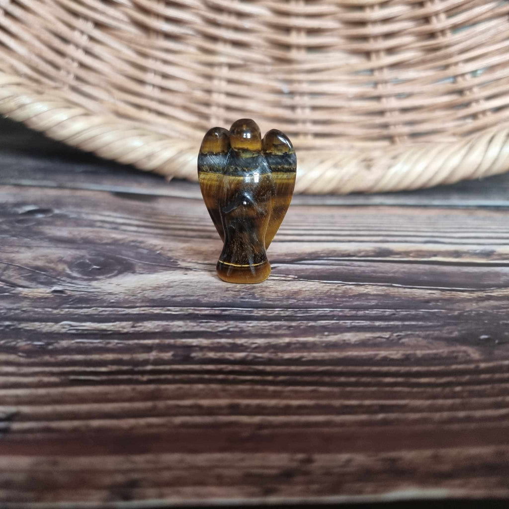 A brown and gold crystal angel on a wooden backdrop 