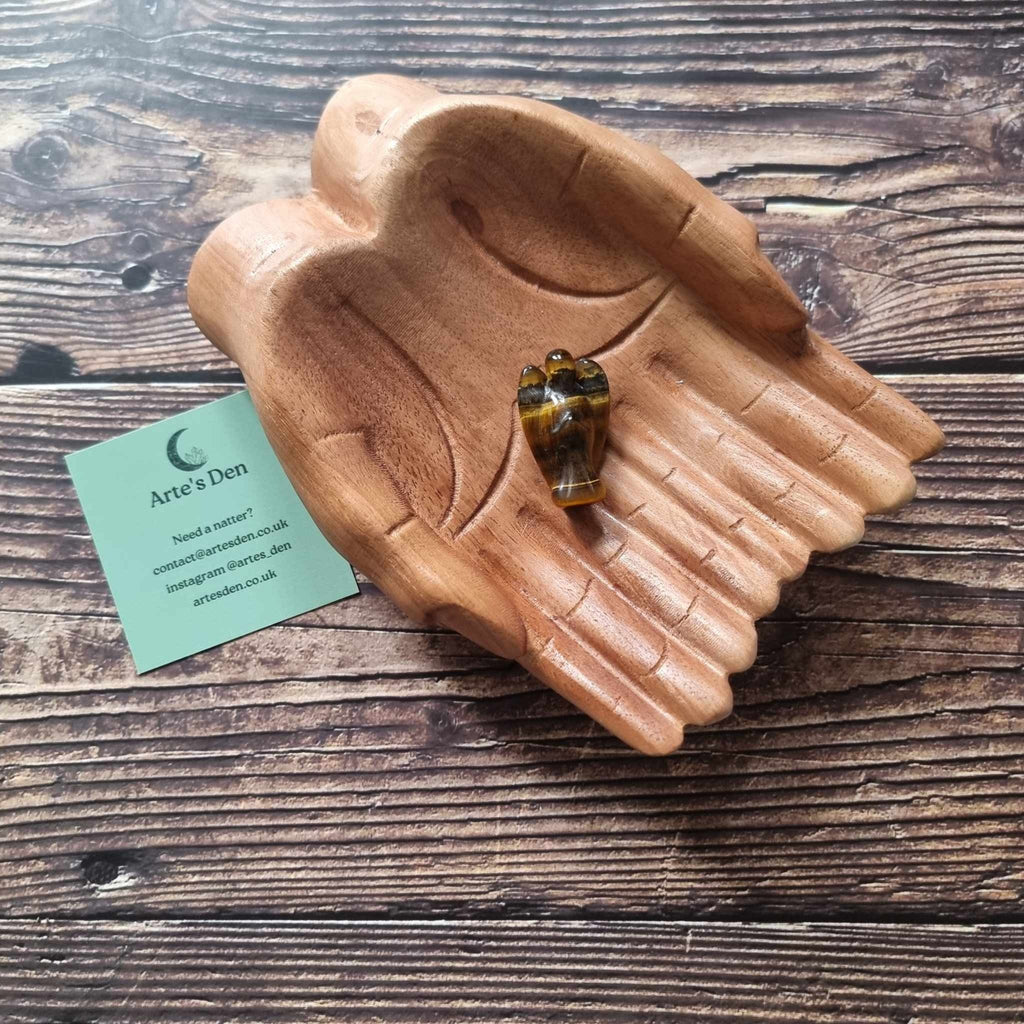 A brown and gold crystal angel on a wooden backdrop 