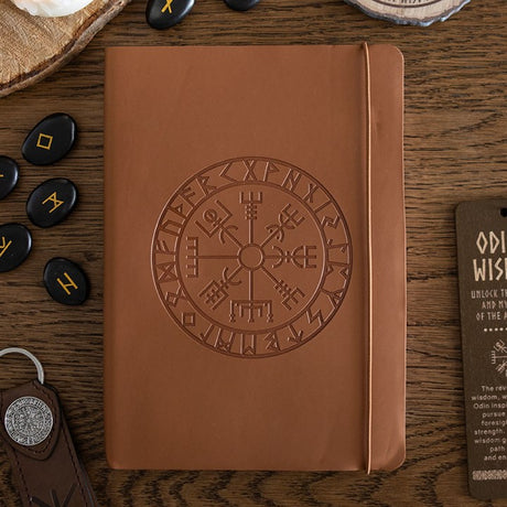 Brown faux leather notebook with embossed Viking design on a wooden surface