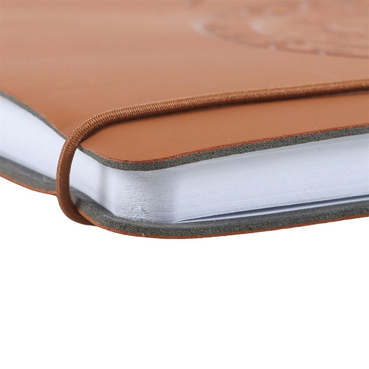 Close-up of a brown faux leather-bound notebook with on a white background