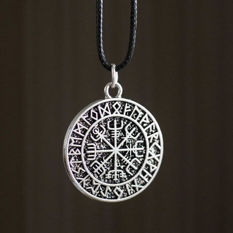 Silver pendant with intricate Viking Norse compass design on a black cord against a dark background