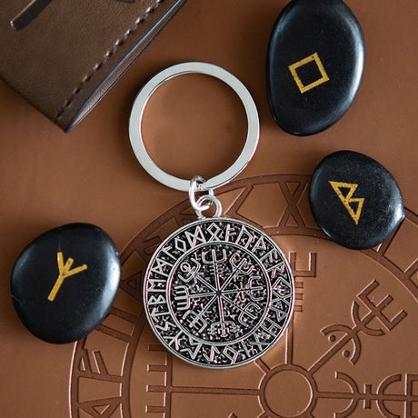 Keychain with Viking Norse Runes on a brown surface with stones featuring symbols