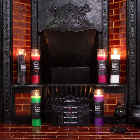 A collection of colourful tube candles displayed in front of a dark fireplace, each with a label indicating different fragrances and uses such as Black Opium, Pink Floral, Green Tea, Lavender, Love, and Happiness.