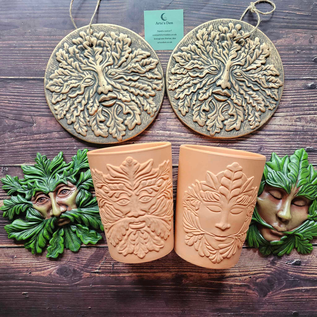 A collection of green man themed plaques and plant pots