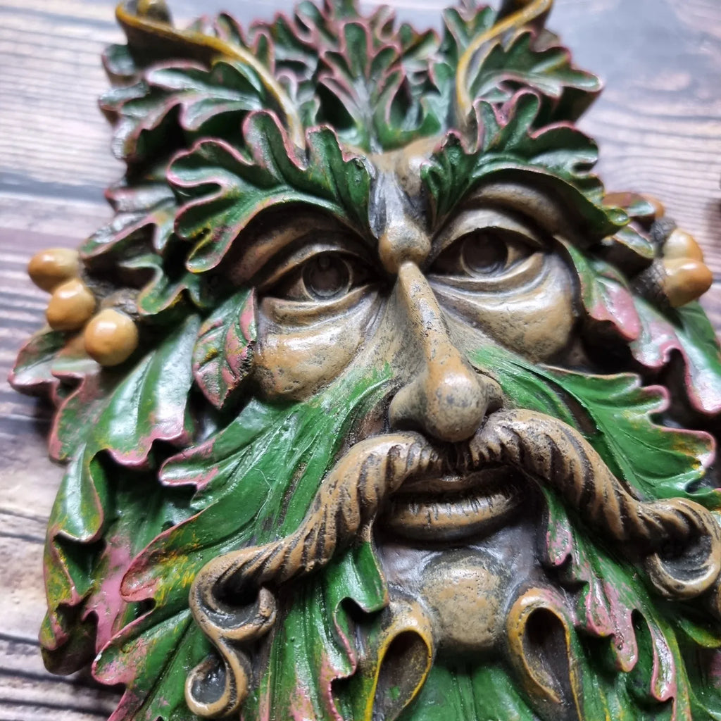 A green man plaque placed against a wooden background