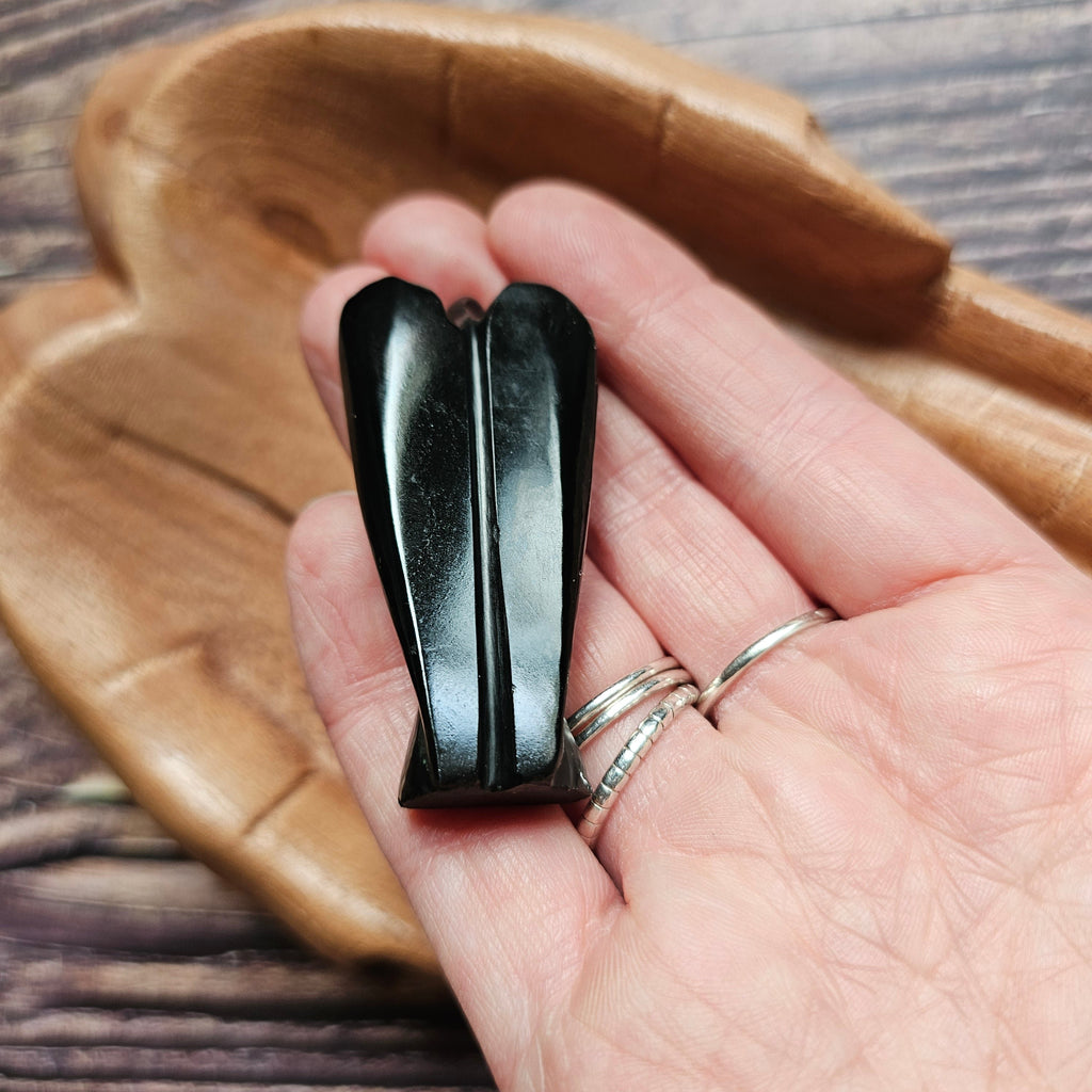 A carved crystal angel figurine held in a hand