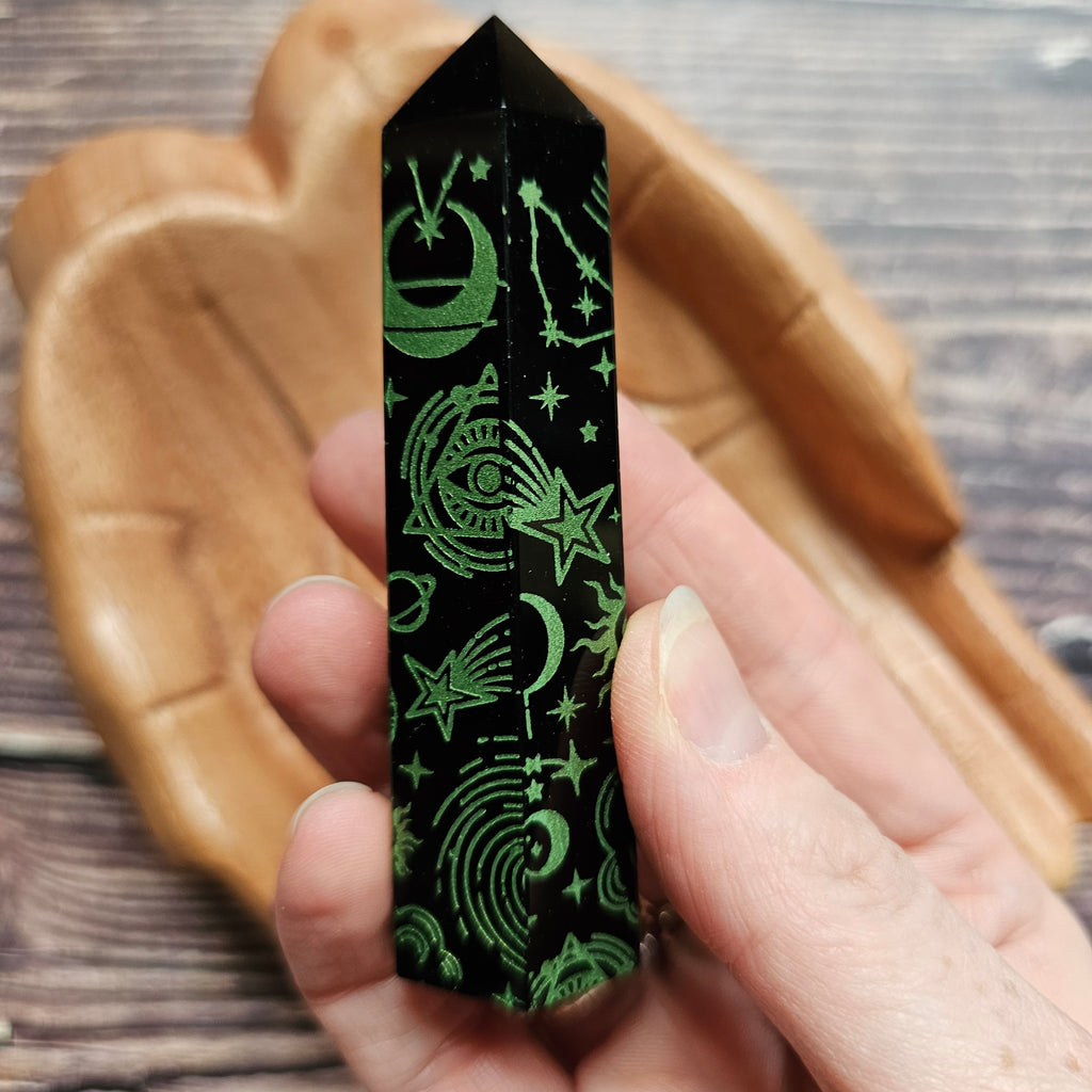 A Black Obsidian Generator with celestial designs held in a hand