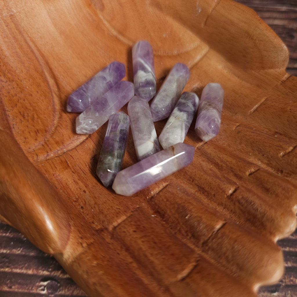 Small Amethyst double pointed crystals held in wooden carved hands