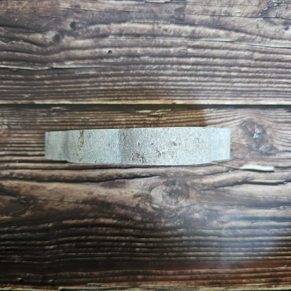 A carved Pink Amethyst crystal shaped as a cloud laid on a wooden background viewed from above
