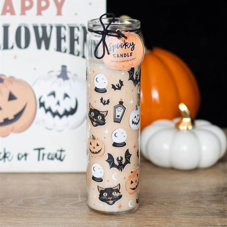 A Spooky Spiced Pumpkin tube candle with a label showing retro black cat and pumpkin print, displayed in front of Halloween-themed decorations.