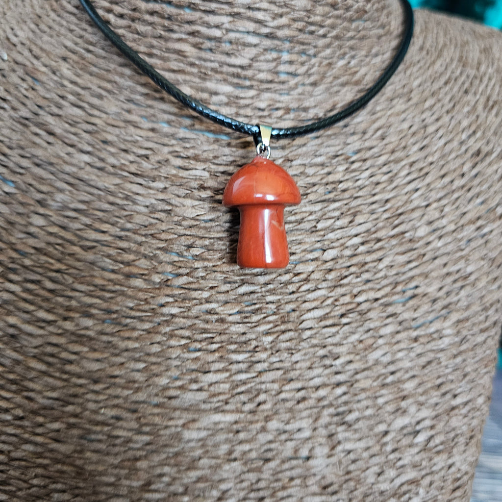 A mushroom-shaped crystal pendant attached to black cord, displayed on a mannequin. 