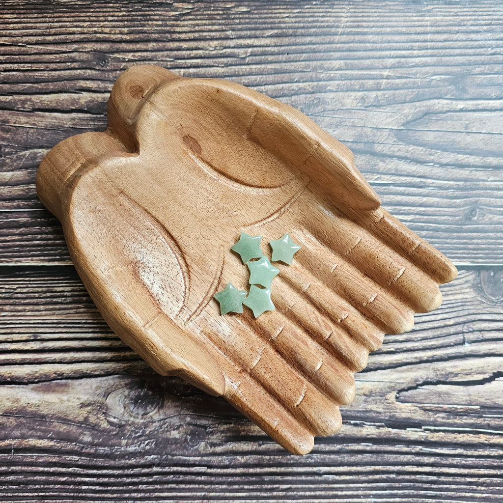 A collection of green aventurine mini stars arranged on a wooden surface.