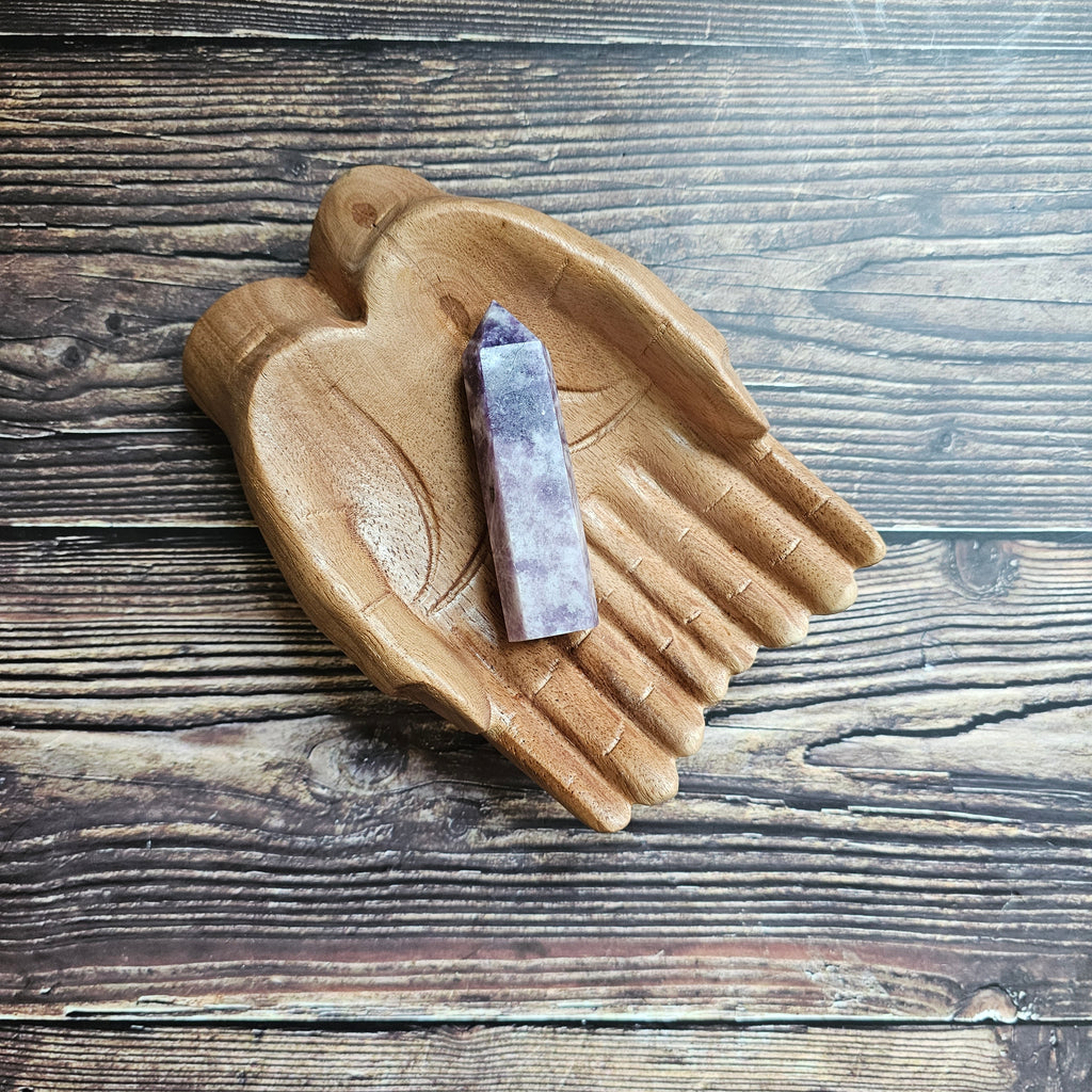 A Lepidolite Generator on a wooden pair of hands