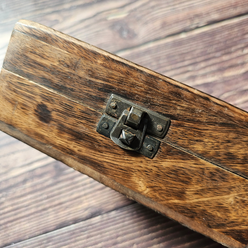 A close up of the closure on a wooden box