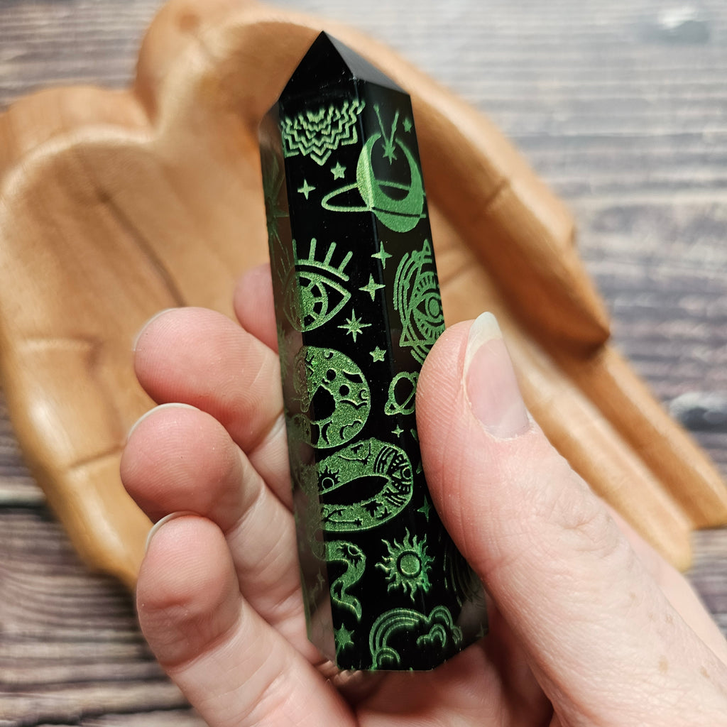 A Black Obsidian Generator with celestial designs held in a hand