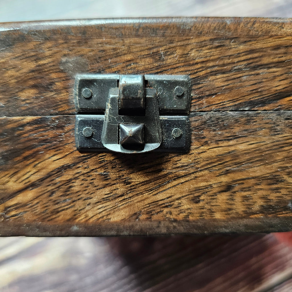 A close up of a metal closure on a wooden box
