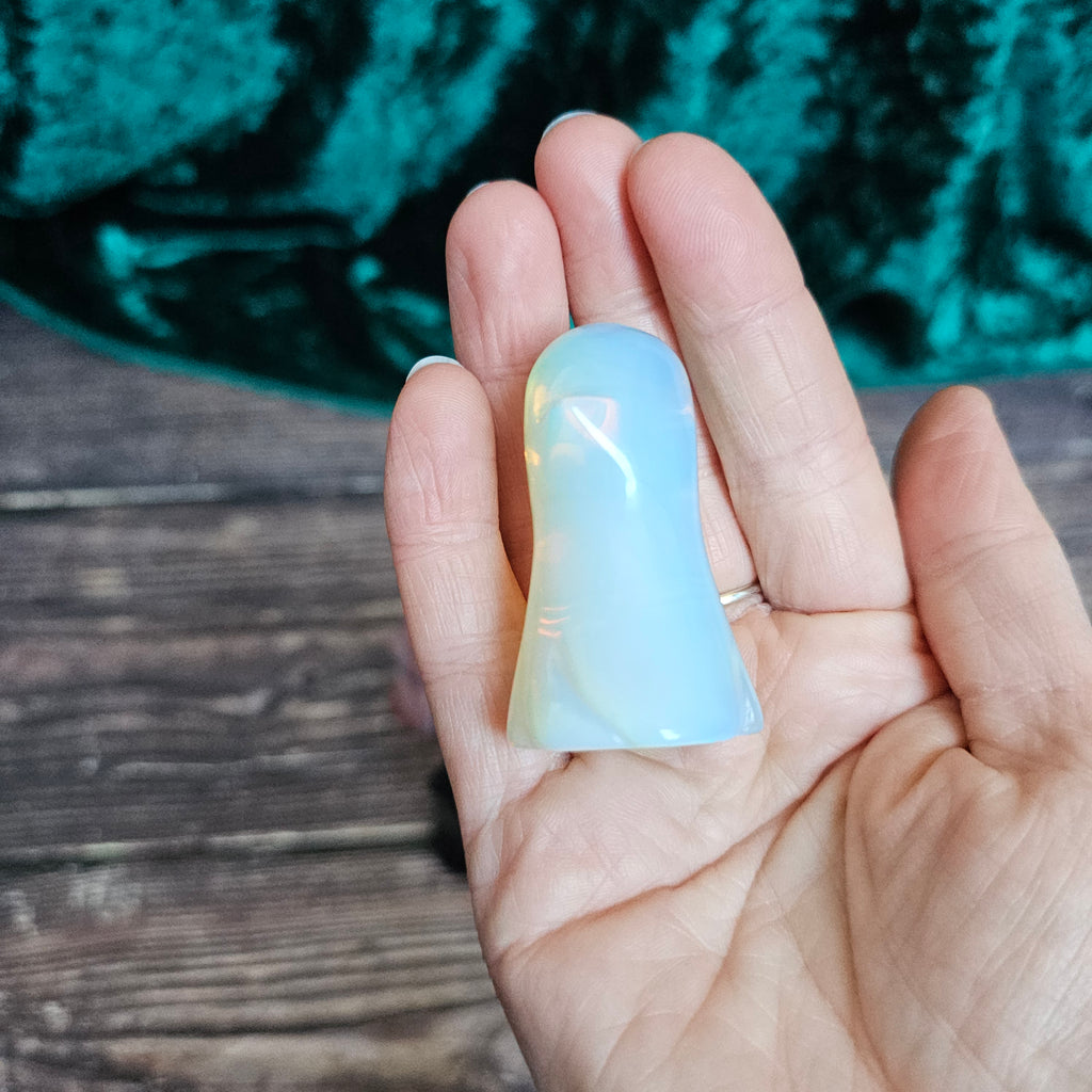 The side of an Opalite carved crystal ghost held in a person's hand