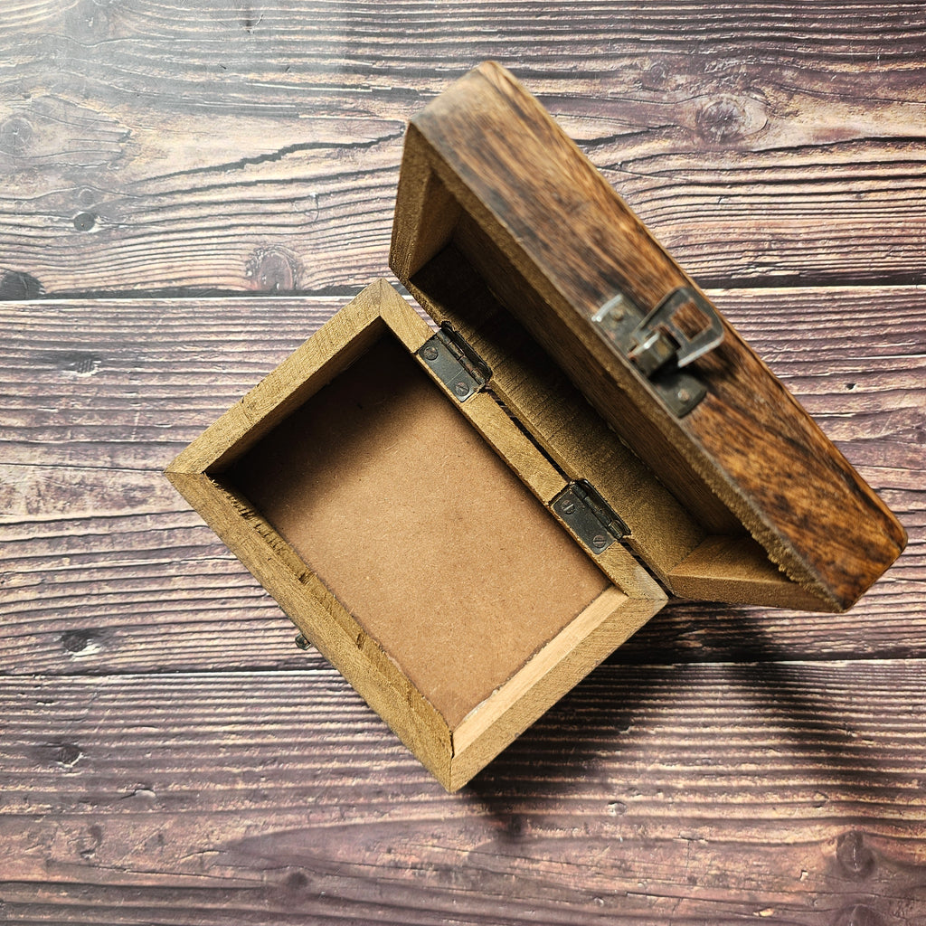 An open, empty wooden box placed on a wooden surface.