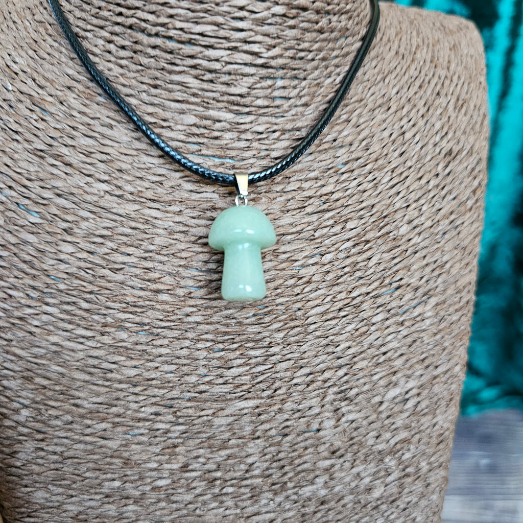A mushroom-shaped crystal pendant attached to black cord, displayed on a mannequin. 