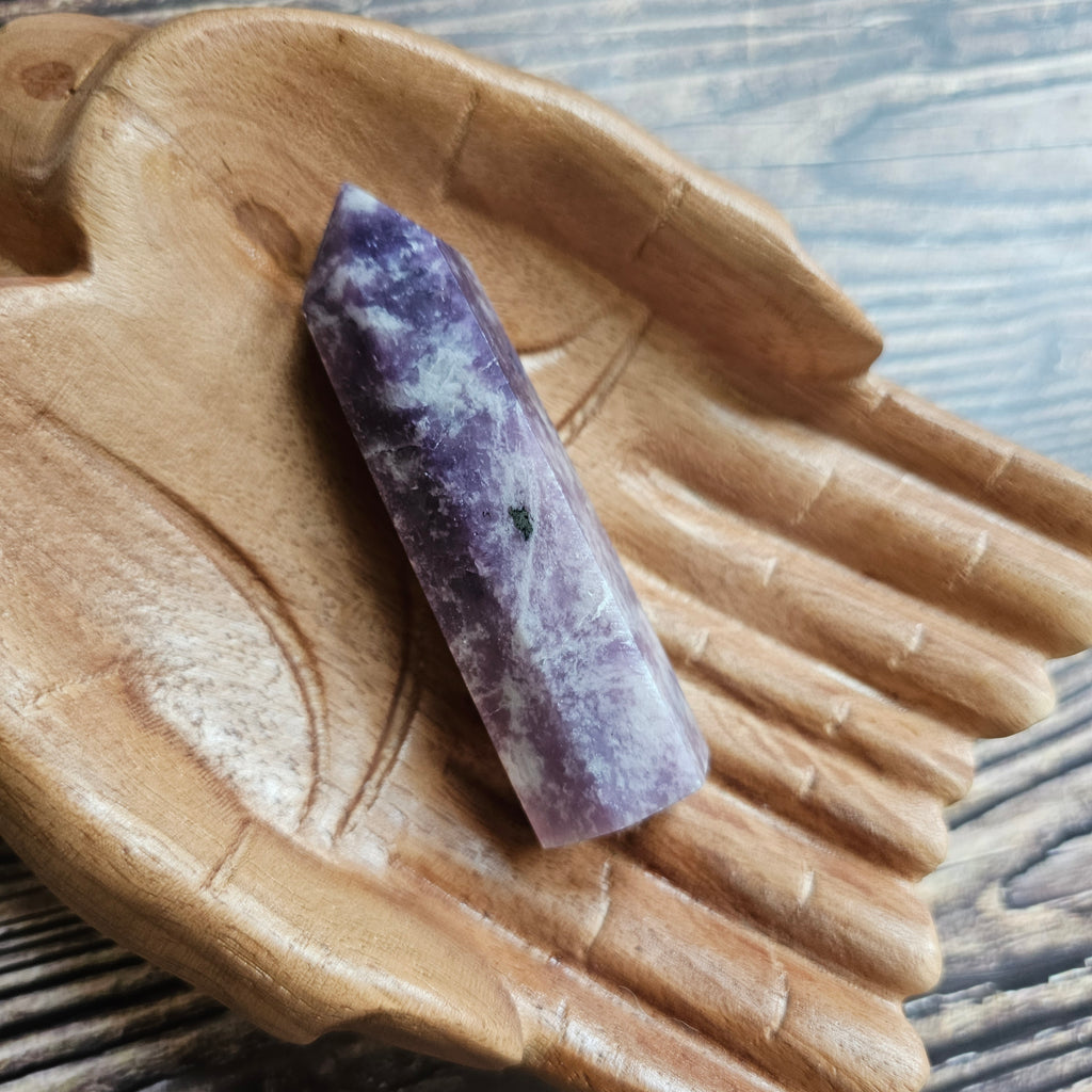 A Lepidolite Generator on a pair of wooden hands