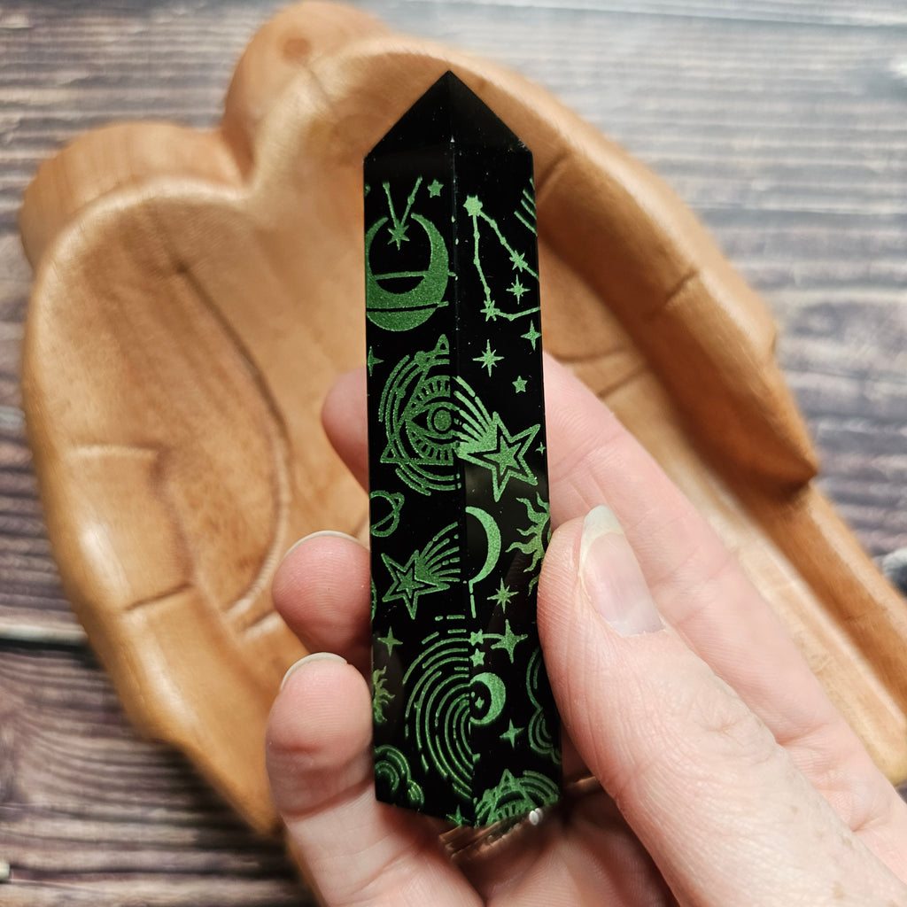 A Black Obsidian Generator with celestial designs held in a hand