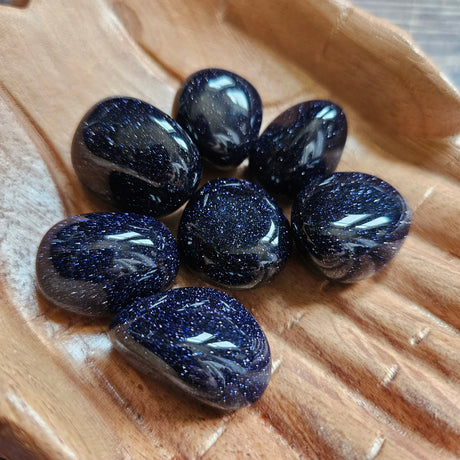 Seven blue crystals on wooden pair of hands