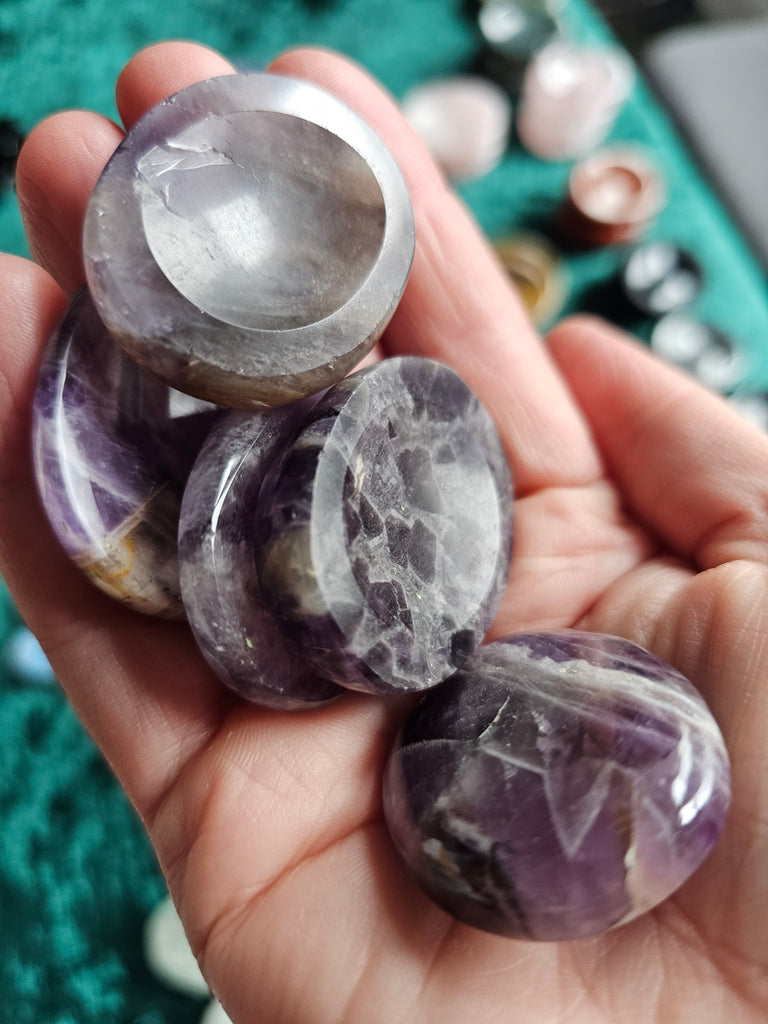 5 Amethyst crystal thumbstones resting being held in a hand