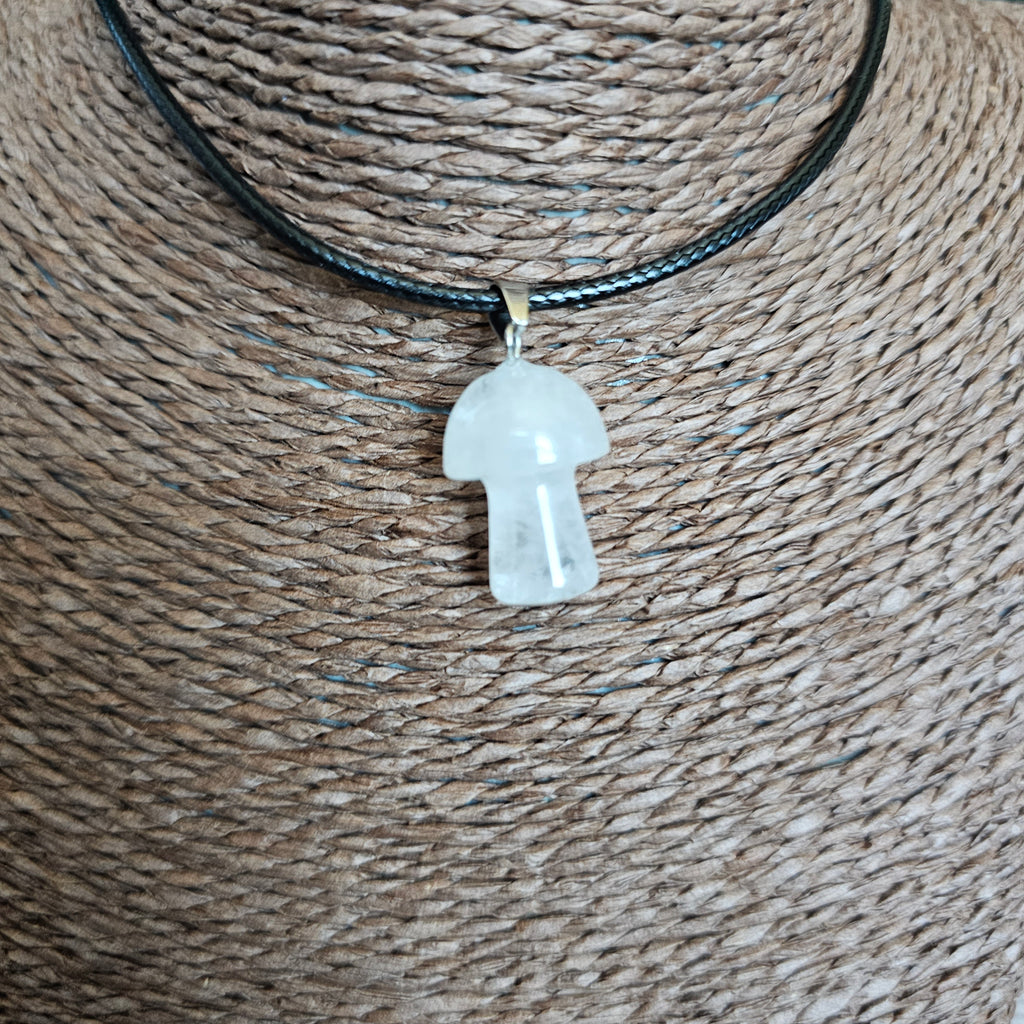 A mushroom-shaped crystal pendant attached to black cord, displayed on a mannequin. 