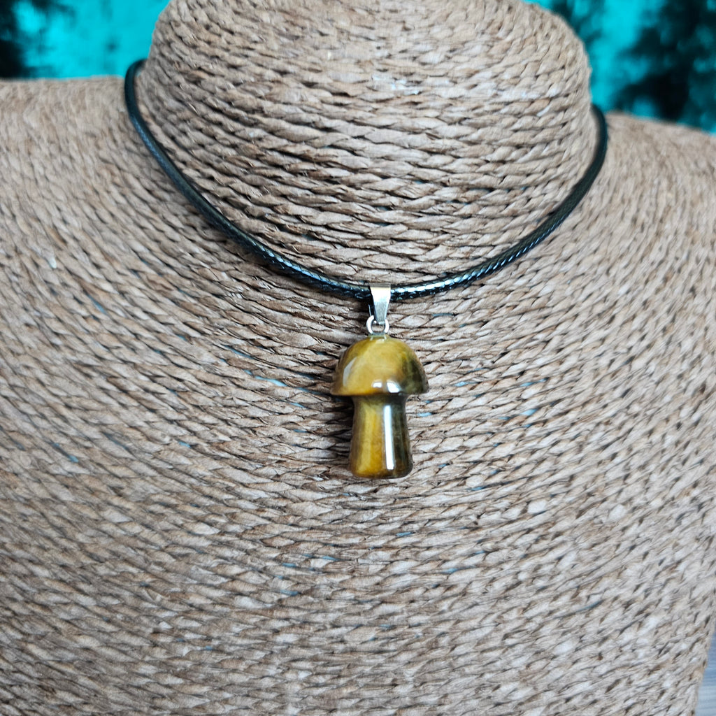 A mushroom-shaped crystal pendant attached to black cord, displayed on a mannequin. 