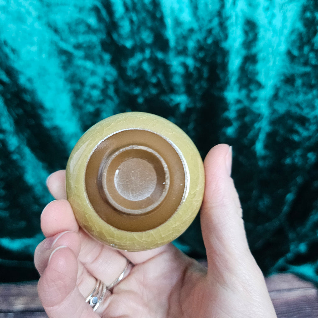 A yellow ceramic tea bowl from underneath 