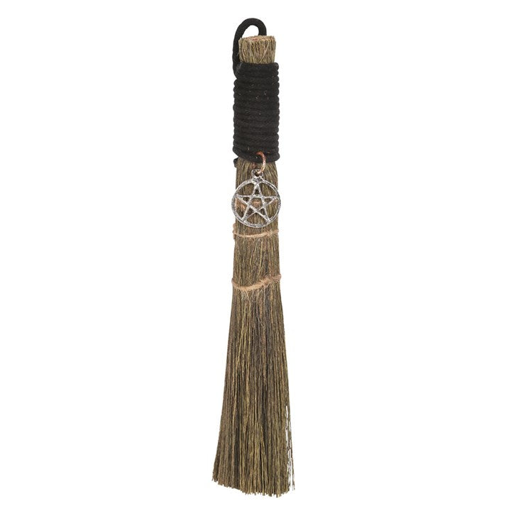 A small traditional broom with a jute string binding and a metal charm, commonly used for spiritual purposes.