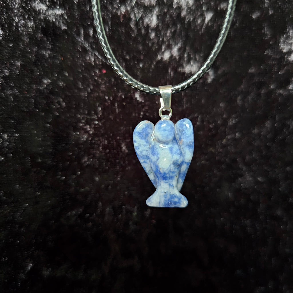 An angel-shaped crystal pendant attached to black cord necklaces on a dark background