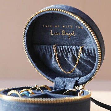 A navy blue travel jewellery case with gold embroidery, featuring a textured surface, a zippered top, and jewellery rolls visible inside.